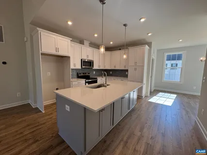 a kitchen that has a lot of cabinets and wooden floor