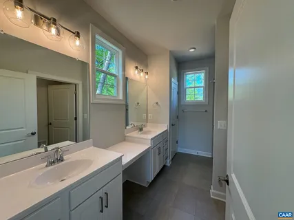a bathroom with a double vanity sink mirror and bathtub