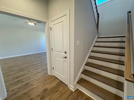 a view of a hallway with wooden floor and entryway