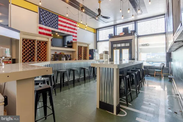 a kitchen with lots of wooden furniture appliances and dining table