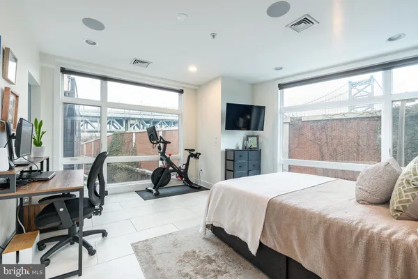 a bedroom with a bed and a flat tv screen on wall