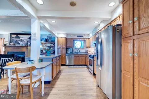 a kitchen with stainless steel appliances granite countertop a sink window and cabinets
