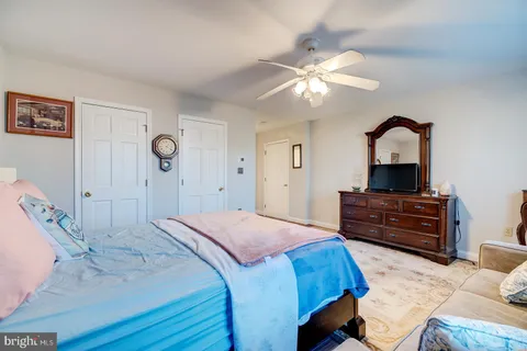 a spacious bedroom with a bed and ceiling fan