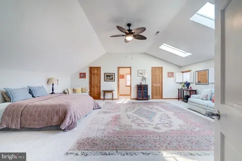 a room with a bed and a chandelier fan