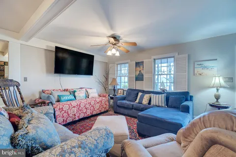 a living room with furniture ceiling fan and a rug