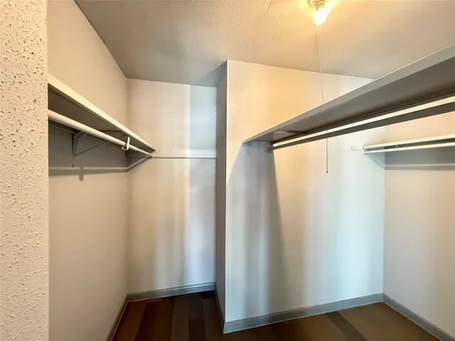 a view of walk in closet with empty racks