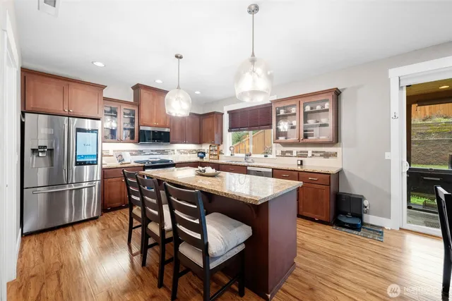 a kitchen with stainless steel appliances granite countertop a sink stove and refrigerator