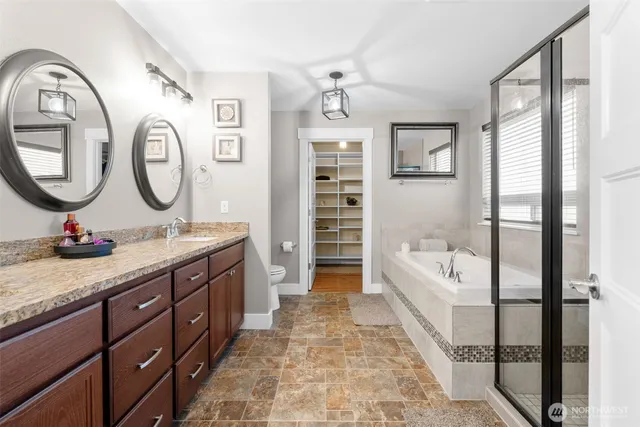 a bathroom with a double vanity sink a toilet a bathtub and shower