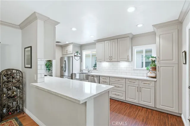 a kitchen with stainless steel appliances a sink a stove a refrigerator and cabinets