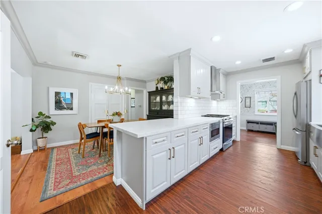 a large kitchen with stainless steel appliances lots of counter space and wooden floor