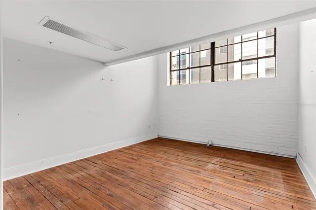 a kitchen with stainless steel appliances granite countertop a refrigerator and a wooden floor