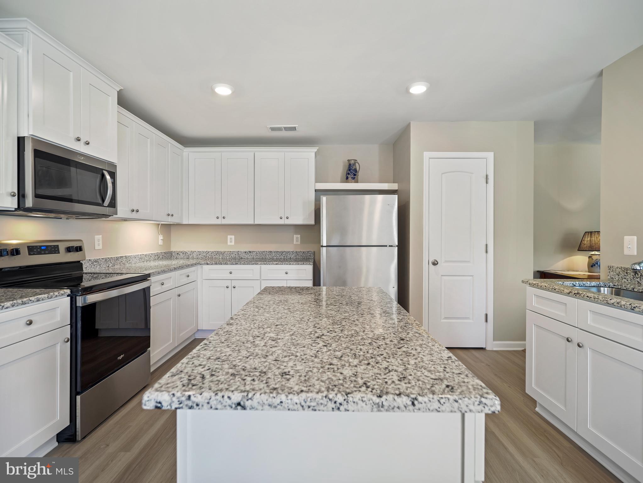 104 Rappahannock Run Falling Waters, WV 25419 - Photo 13 of 41 a kitchen with kitchen island granite countertop a stove and a sink