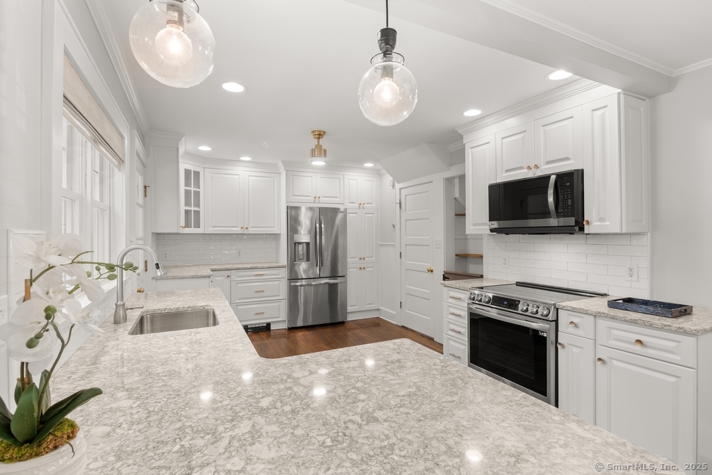 223 Middlesex Road Darien, CT 06820 - Photo 5 of 24 a kitchen with stainless steel appliances granite countertop a sink a stove and a refrigerator