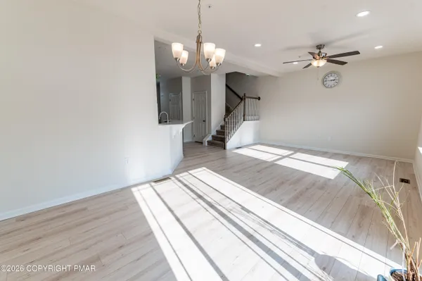 a view of a room with wooden floor and fan