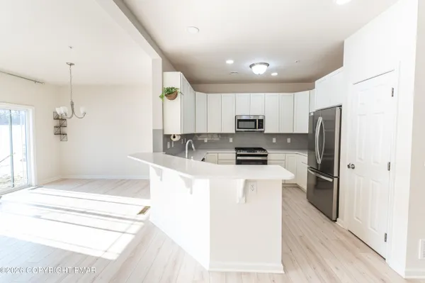 a large kitchen with a refrigerator a stove top oven a sink and dishwasher