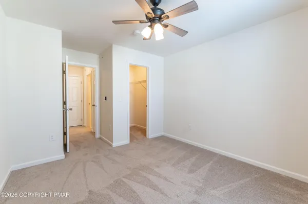 an empty room with closet and a chandelier fan