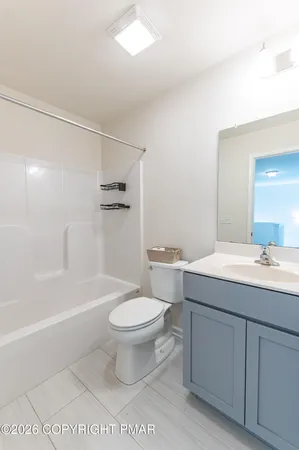 a bathroom with a granite countertop toilet a sink and a bathtub