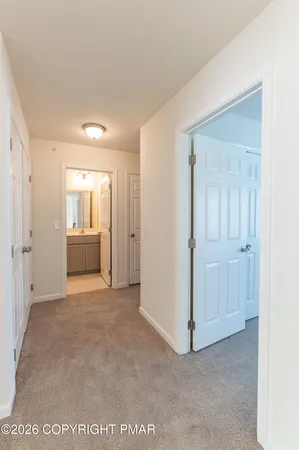 a view of an empty room and a kitchen