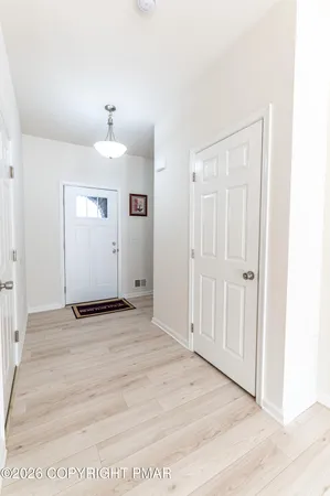 a view of a room with wooden floor and white walls