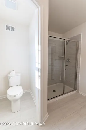 a bathroom with a toilet and a shower
