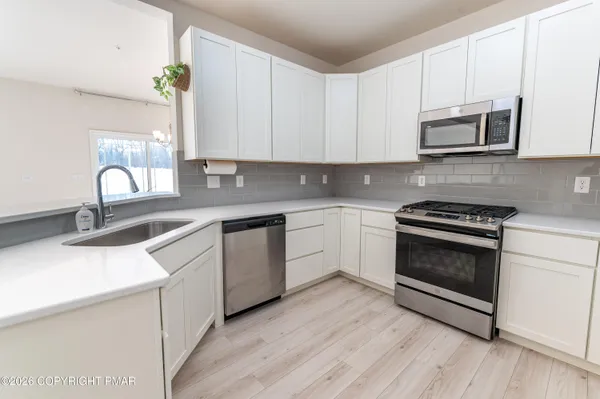 a kitchen with granite countertop a sink stainless steel appliances and cabinets