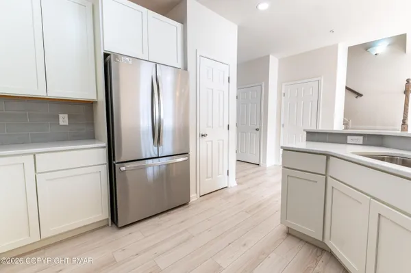 a kitchen with stainless steel appliances a refrigerator sink and cabinets