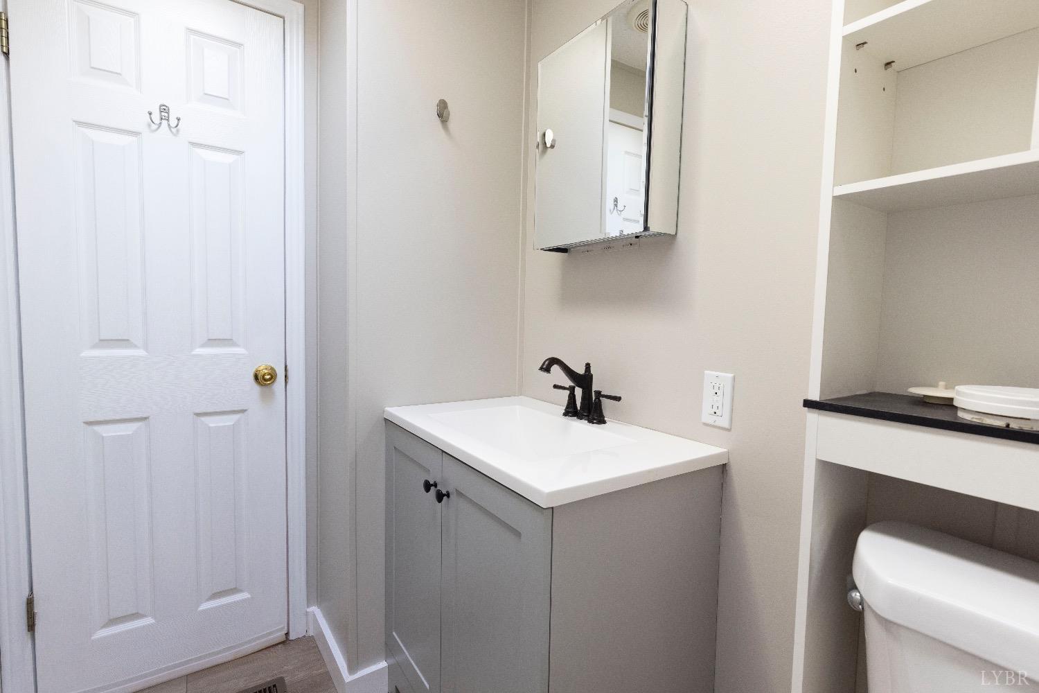 2540 Goode Road Goode, VA 24556 - Photo 24 of 37 a bathroom with a sink a toilet and a mirror