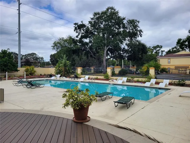 a swimming pool with outdoor seating and barbeque oven