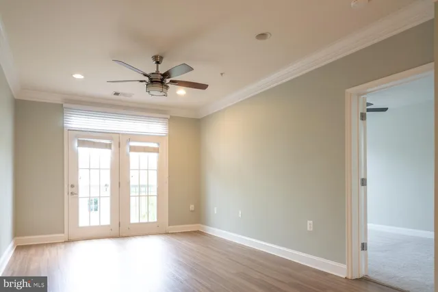 a view of an empty room with a window and a ceiling fan
