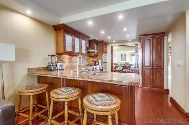 a kitchen with a dining table chairs and sink