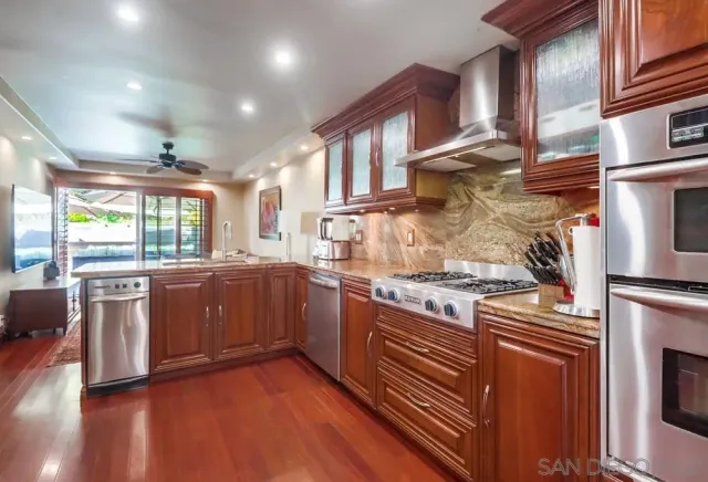 a kitchen with stainless steel appliances granite countertop a stove and a sink