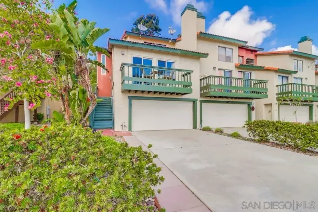 a front view of a house with a garden and plants