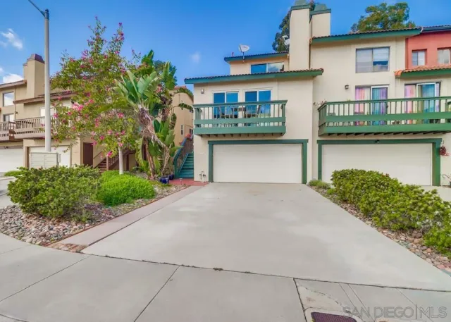 a front view of a house with a yard and potted plants