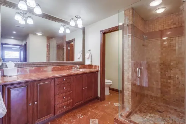 a bathroom with a granite countertop sink a large mirror and a shower