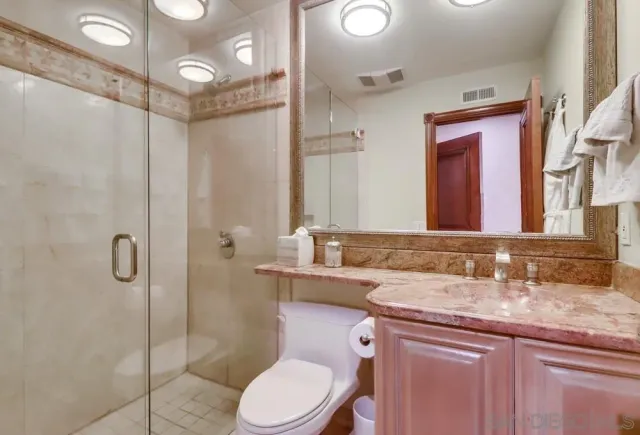 a bathroom with a granite countertop sink toilet and shower