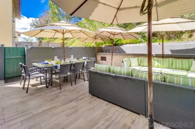 a view of a patio with table and chairs under an umbrella