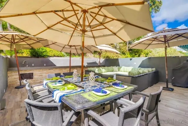 a view of a patio with a table and chairs under an umbrella