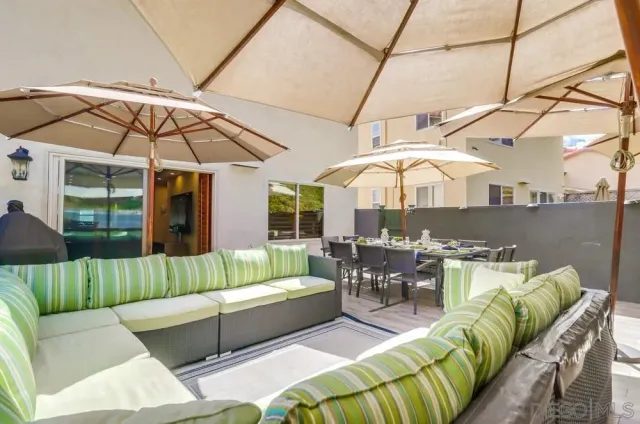 a view of a swimming pool with couches chairs under an umbrella
