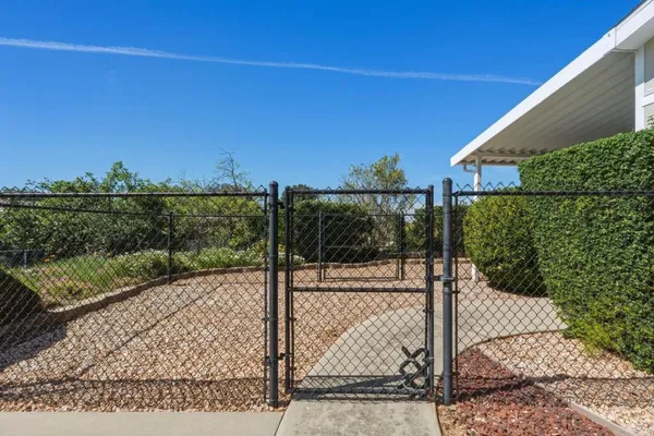 a view of a pathway with a wrought fence