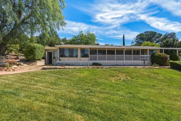 a view of a house with backyard and porch