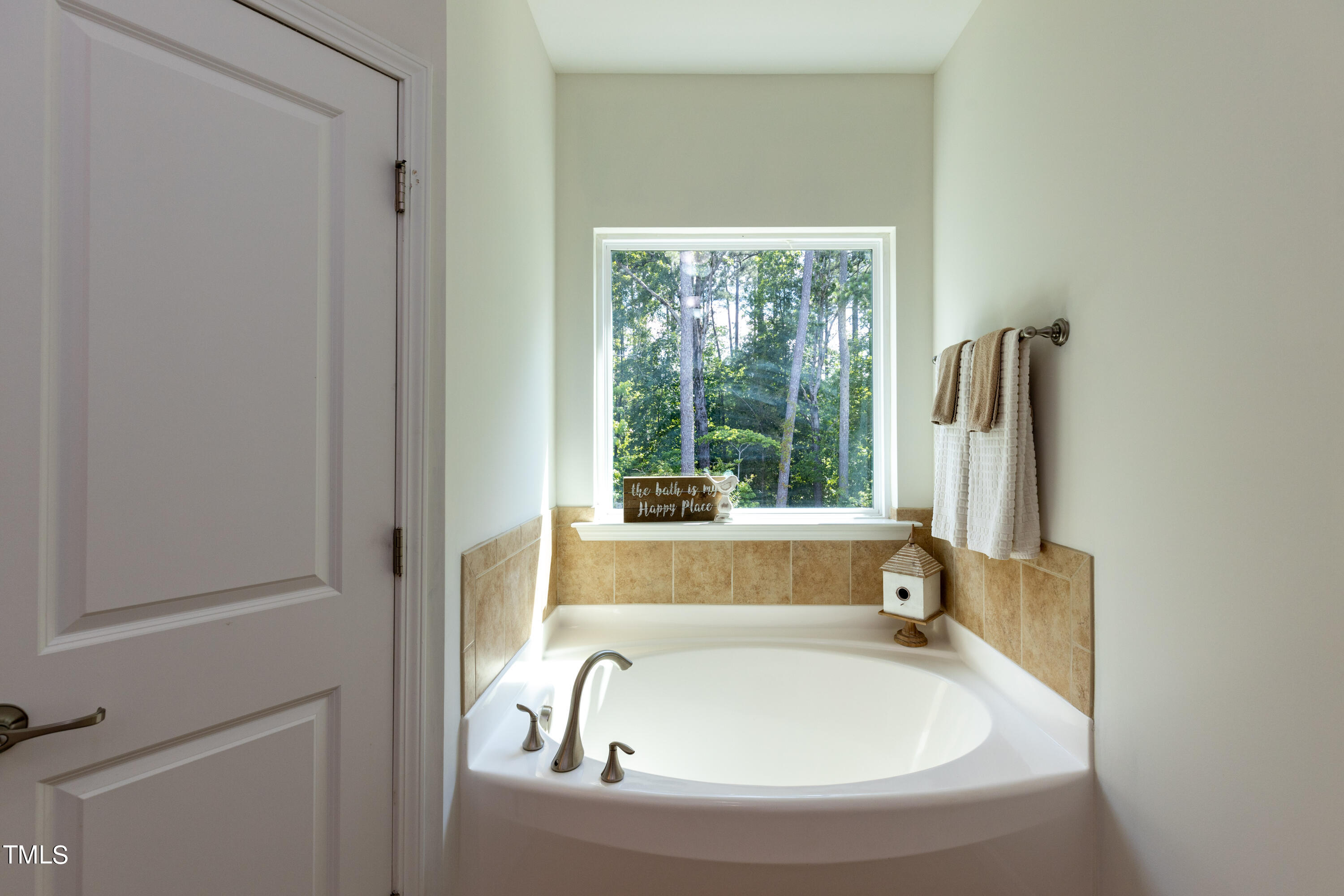 711 Edgewater Ridge Court Apex, NC 27523 - Photo 17 of 29 a bathroom with bathtub and window