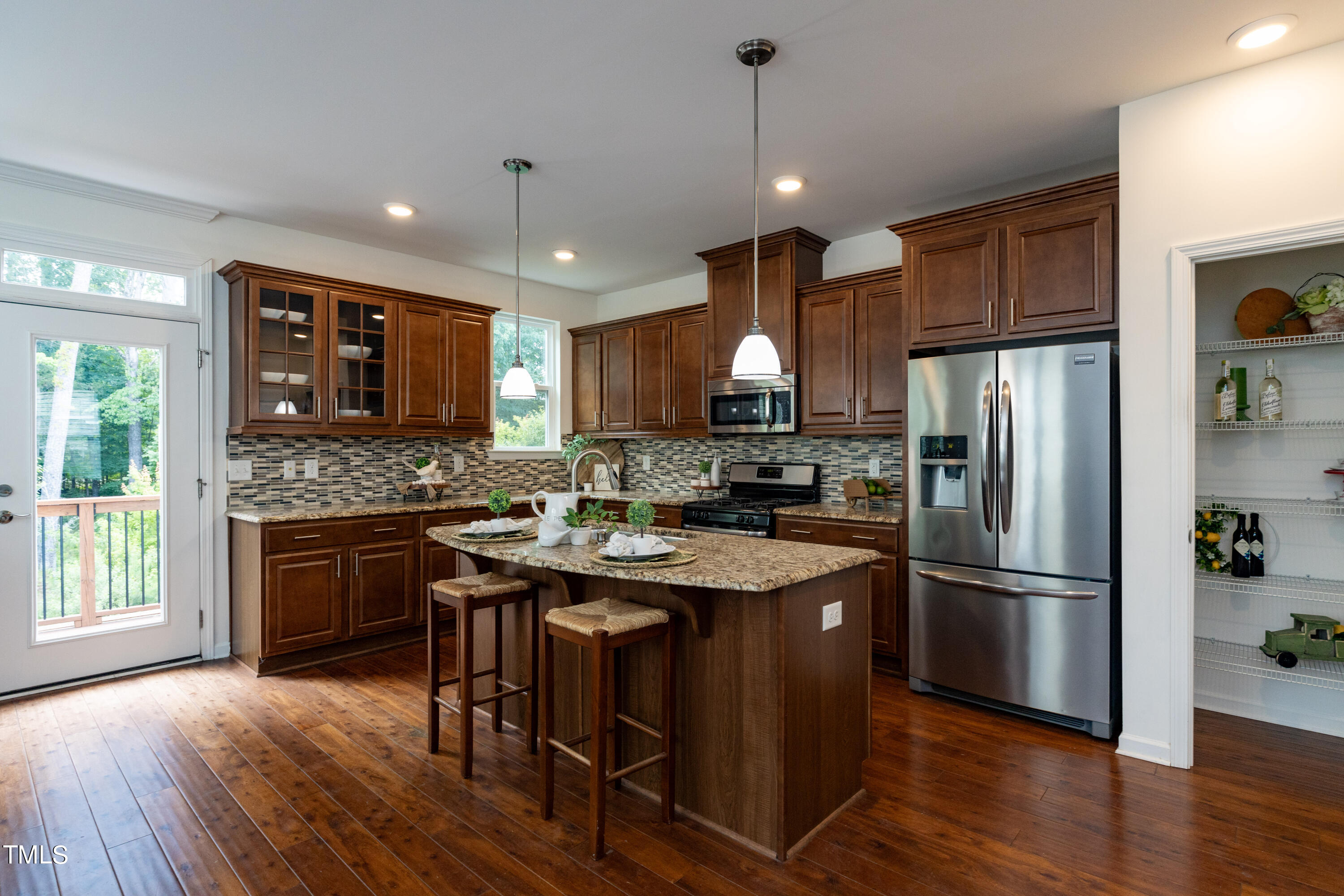 711 Edgewater Ridge Court Apex, NC 27523 - Photo 9 of 29 a kitchen with stainless steel appliances granite countertop a refrigerator a stove a sink dishwasher a microwave oven with cabinets and wooden floor