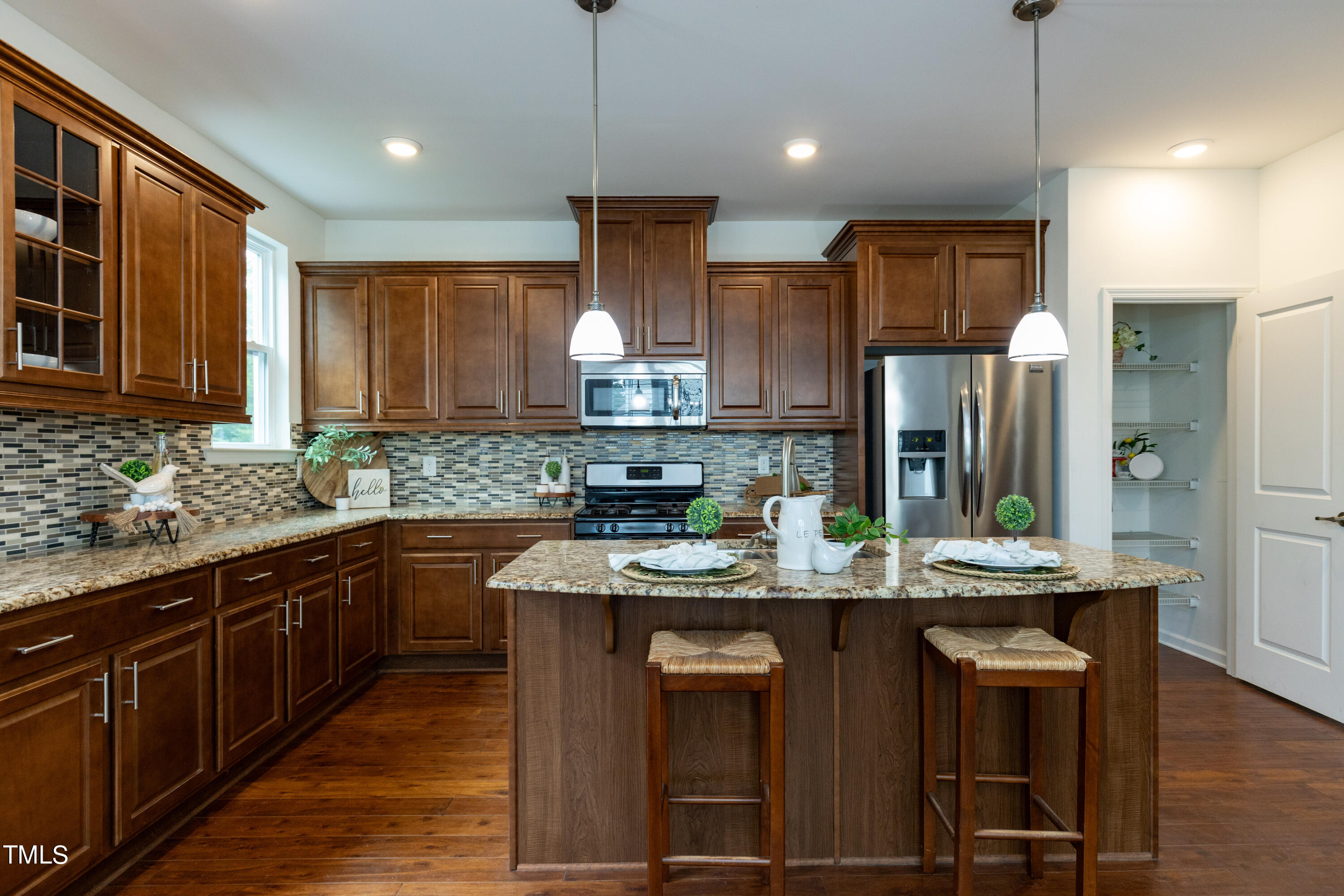 711 Edgewater Ridge Court Apex, NC 27523 - Photo 10 of 29 a kitchen with kitchen island granite countertop a sink appliances and cabinets