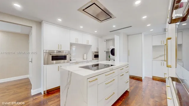 a kitchen that has a sink a refrigerator and a stove top oven