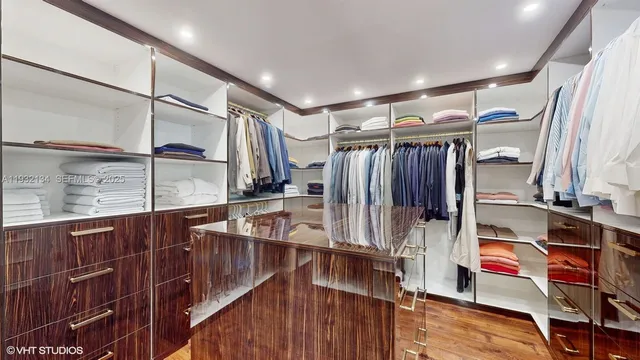 a view of walk in closet with clothes and shoes