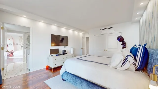 a bedroom with a bed and flat screen tv