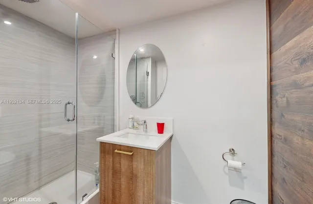 a bathroom with a sink vanity mirror and shower