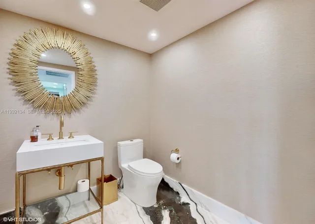 a bathroom with a sink a toilet and a mirror