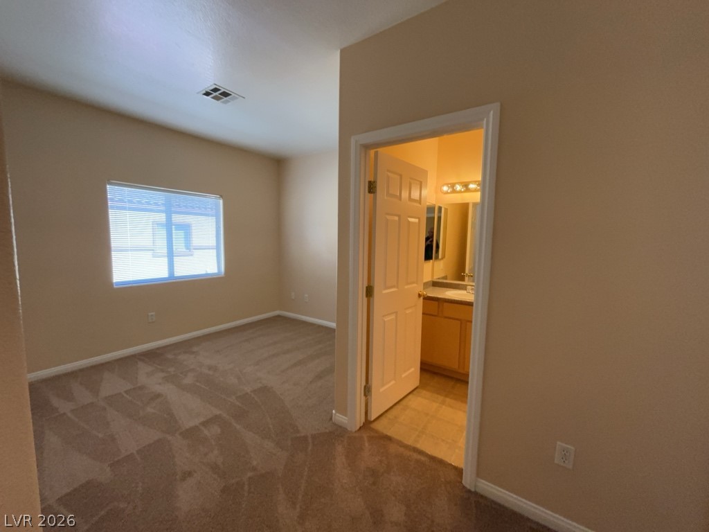 4915 East Russell Road, Unit 145 Las Vegas, NV 89120 - Photo 6 of 13 Unfurnished bedroom with light colored carpet and ensuite bathroom