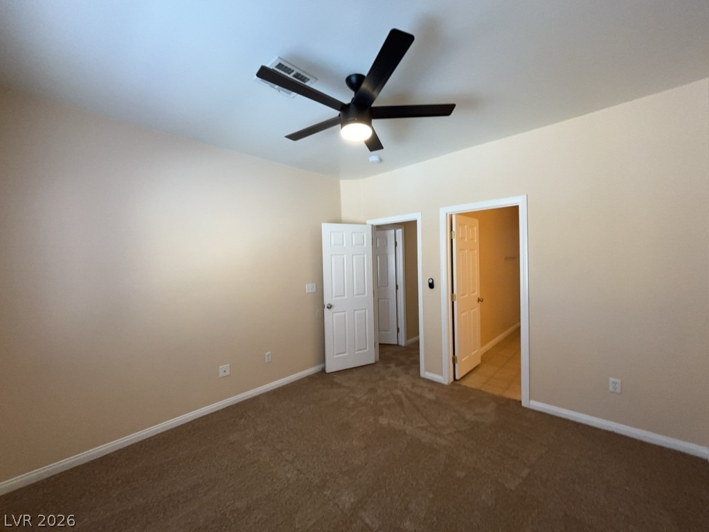 4915 East Russell Road, Unit 145 Las Vegas, NV 89120 - Photo 7 of 13 Unfurnished bedroom featuring dark carpet and a ceiling fan
